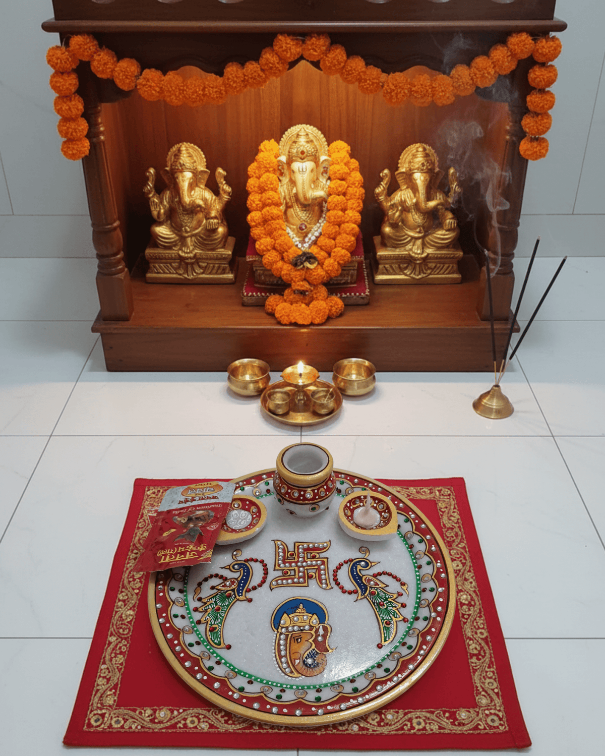 Intricate hand-painted Lord Ganesha and Swastik artwork on a traditional marble pooja plate
