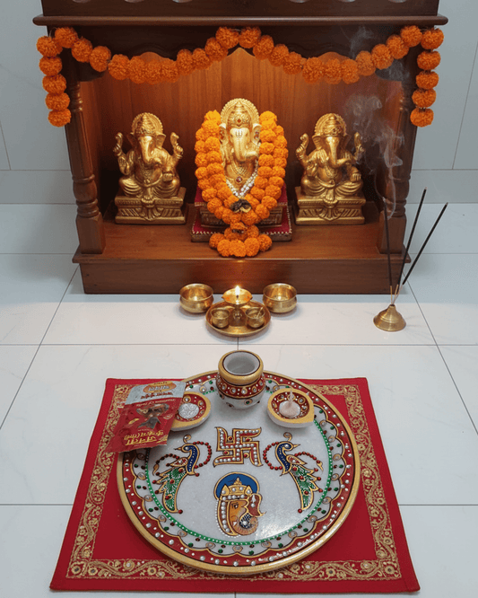 Intricate hand-painted Lord Ganesha and Swastik artwork on a traditional marble pooja plate