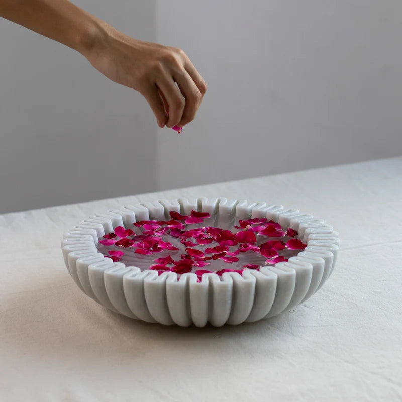 Scalloped marble Urli bowl decorated with floating flowers and candles for home decor