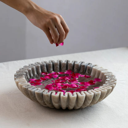 Scalloped marble Urli bowl decorated with floating flowers and candles for home decor