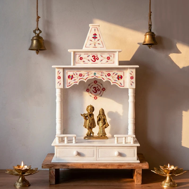 Beautifully decorated white marble temple with red inlay set up for daily pooja