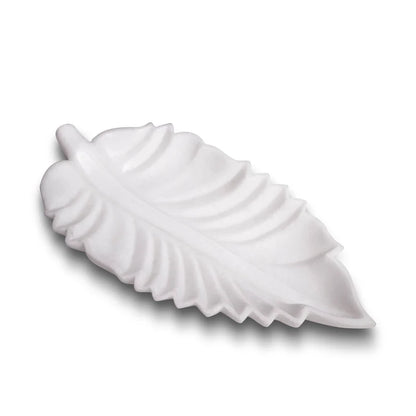 Leaf-shaped white marble Urli bowl decorated with floating flowers and candles for home decor