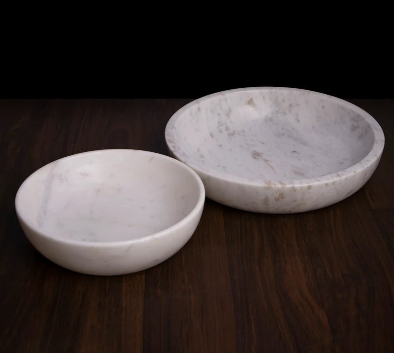 White marble dual-purpose Urli fruit bowl styled on a dining room table