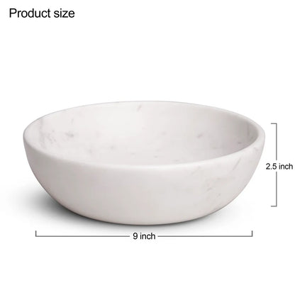 White marble dual-purpose Urli fruit bowl styled on a dining room table