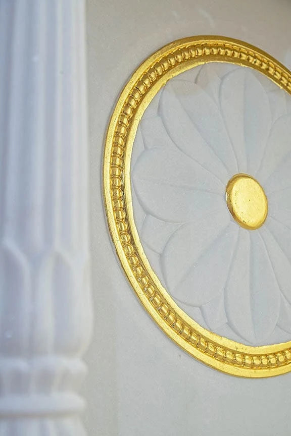 Close-up of chakra carving and pillars on marble pooja mandir