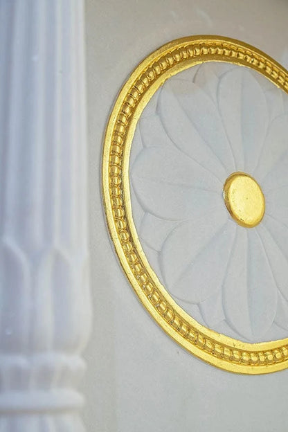 Close-up of chakra carving and pillars on marble pooja mandir