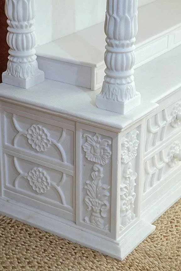 Close-up of chakra carving and pillars on marble pooja mandir