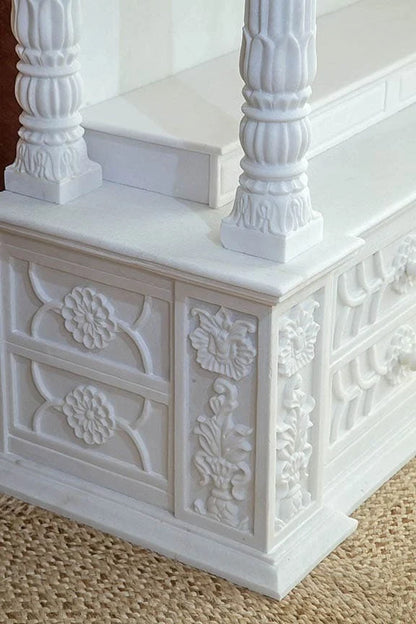 Close-up of chakra carving and pillars on marble pooja mandir
