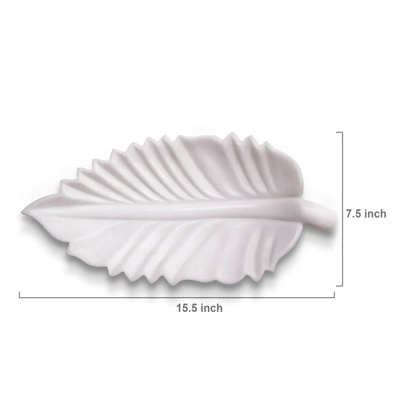 Leaf-shaped white marble Urli bowl decorated with floating flowers and candles for home decor