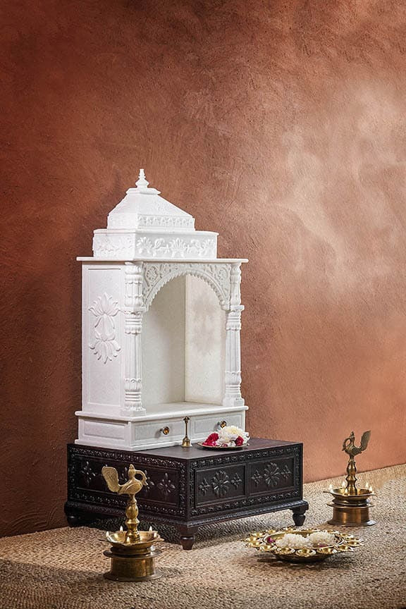 Inner sanctum view of traditional white marble temple with toran motif
