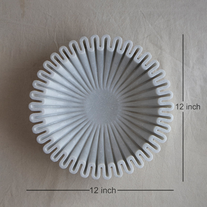 Close-up of floral scalloped rim and smooth interior of white marble Urli