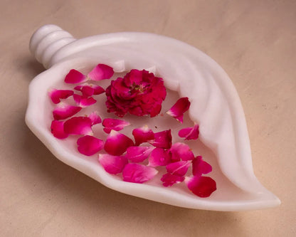 Shell-shaped white marble Urli bowl decorated with floating flowers and candles for home decor