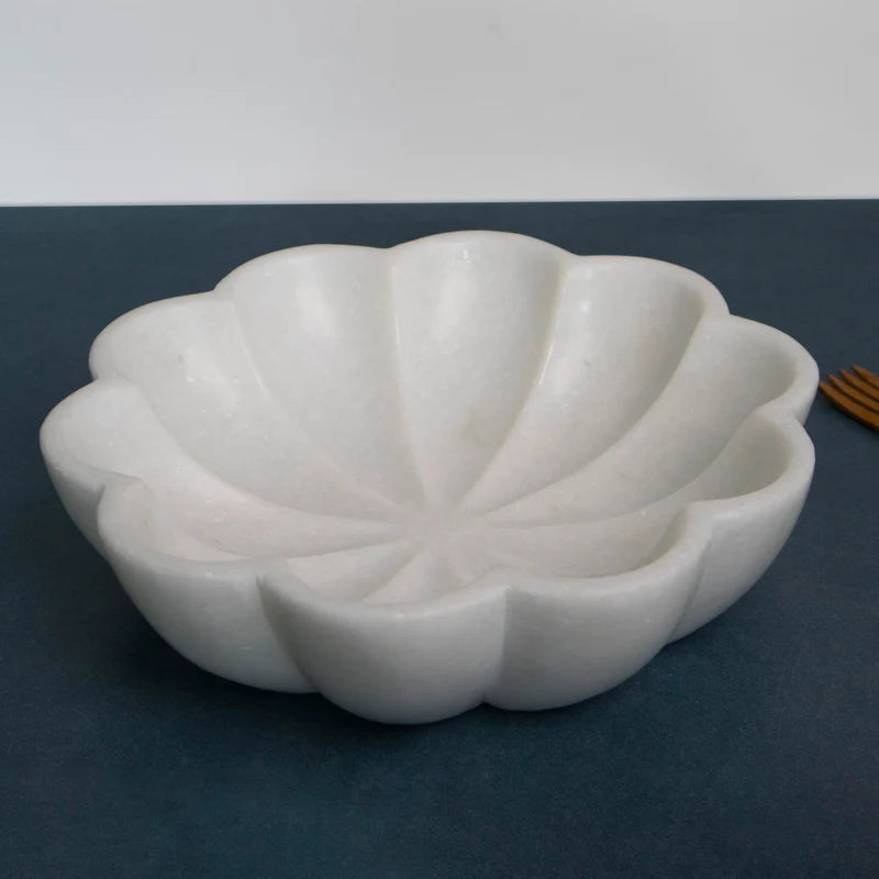 White marble fruit bowl filled with fresh fruits on dining table setup
