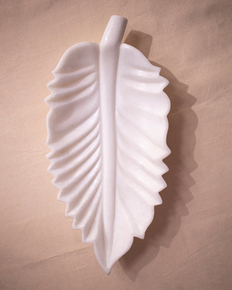 Close-up of organic leaf contour and smooth finish on white marble Urli